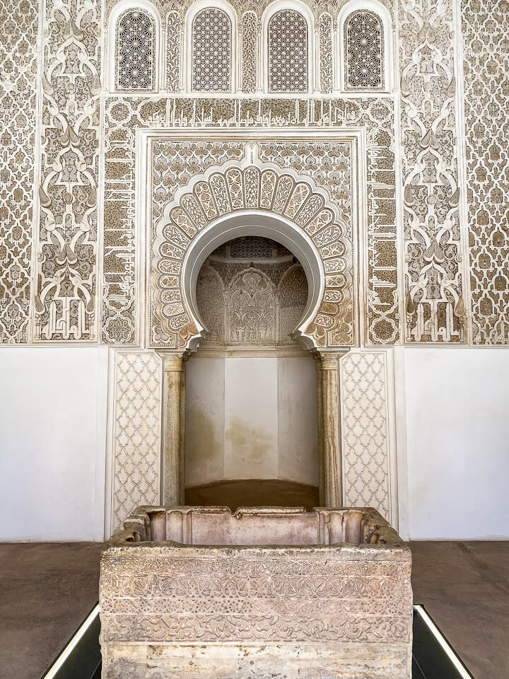 The 500-year-old Koranic school Medersa Ben Youssef in Marrakech is one of the most important monuments in Morocco. Marble water basin and decorated nishrab in the prayer room.