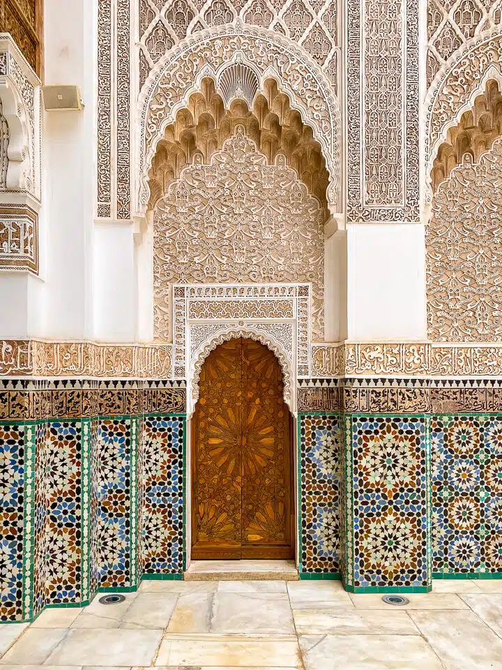 Islamic stucco decorations and tile mosaics in the courtyard of the Ben Youssef Madrasa Marrakesh.